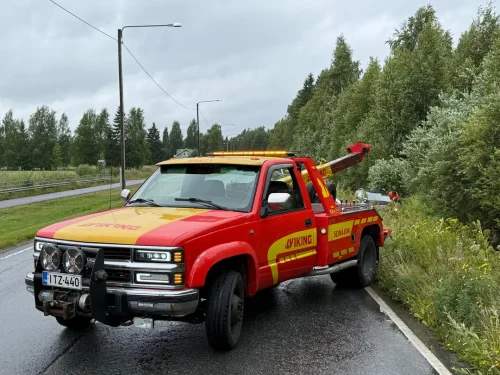 Eka24 pick up- hinausauto asfalttitiellä vetämässä henkilöautoa ojasta.